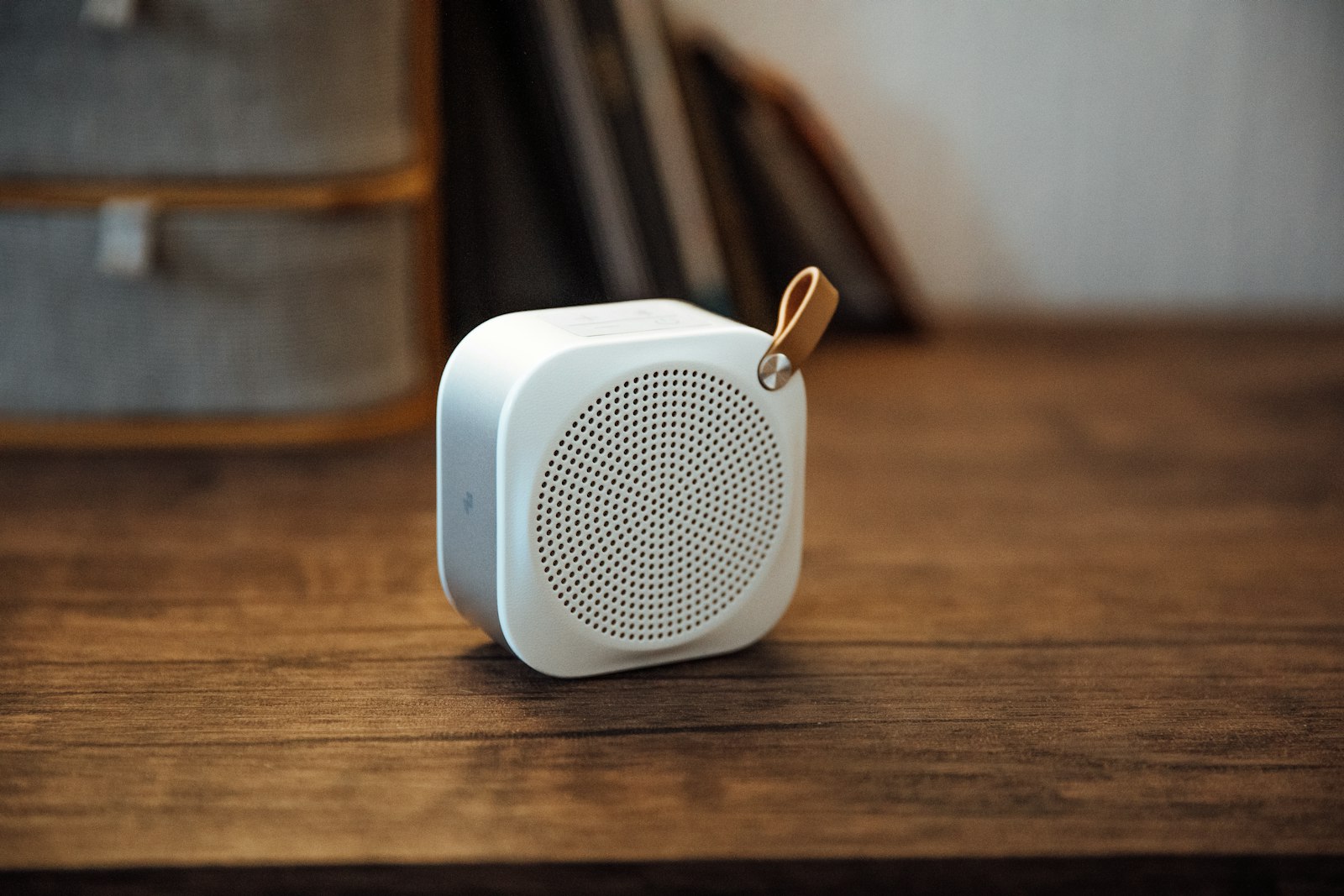 A compact Sonos portable speaker on a wooden table