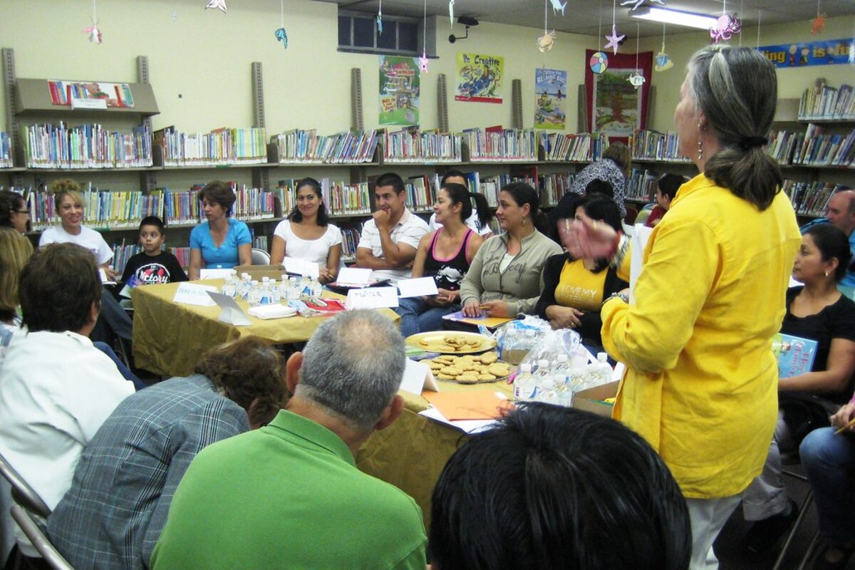 A group of adult learners in an English conversation club at a public library.