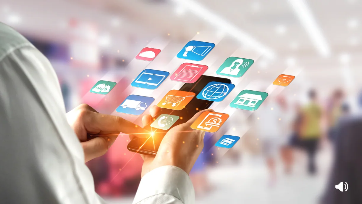 Mano che tiene uno smartphone con icone di app di shopping sospese sopra di esso.
