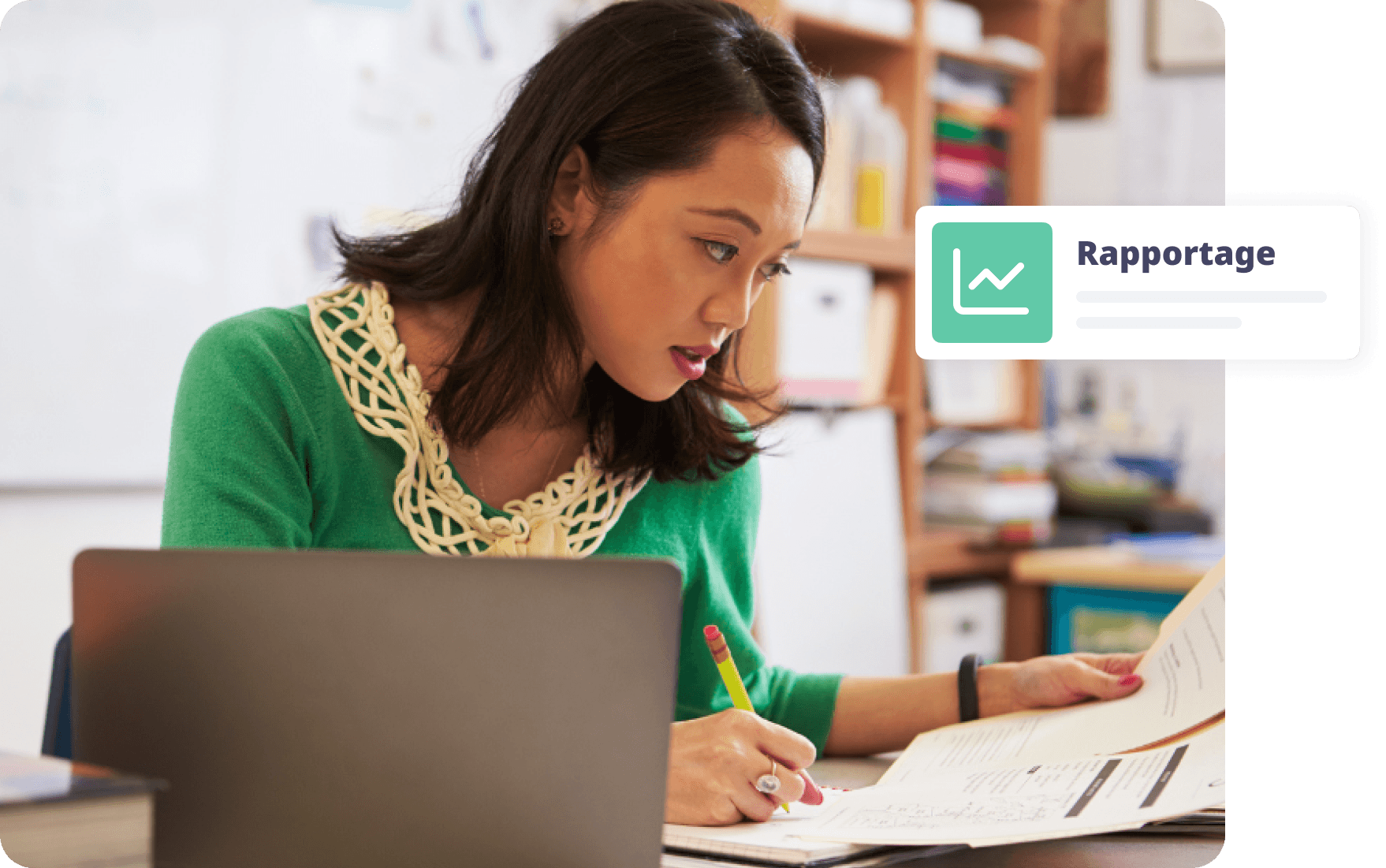 Vrouw in groene trui maakt aantekeningen terwijl ze naar rapporten kijkt aan een bureau.