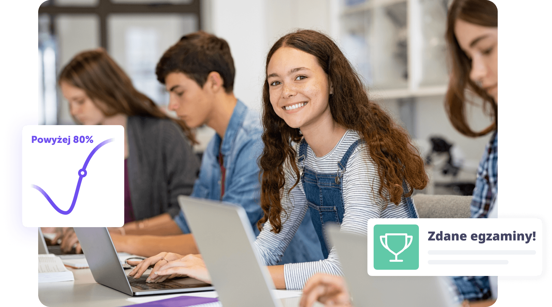 Uśmiechnięta uczennica pracująca na laptopie w klasie z innymi studentami.