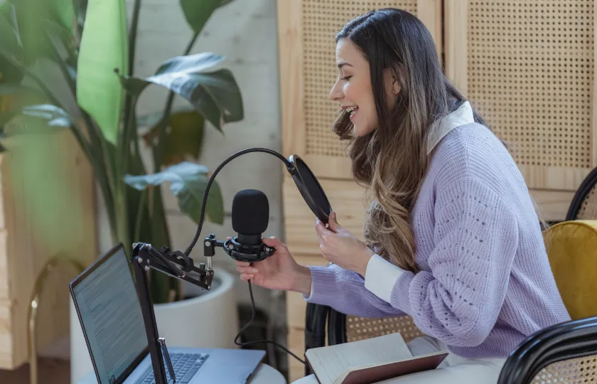 Woman using recording equipment to create a podcast voice over