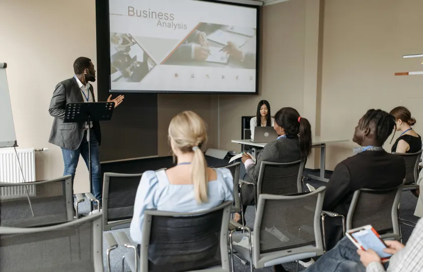 Man in black blazer having a presentation in front of employees demonstrating universal design for learning (UDL) principles for workplace training