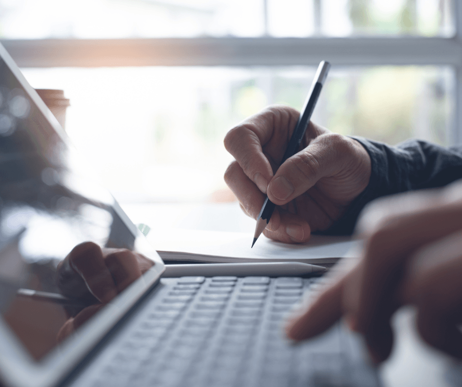 A hand is holding a pen and writing.