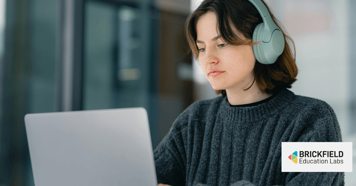 Una donna con le cuffie davanti a un computer.