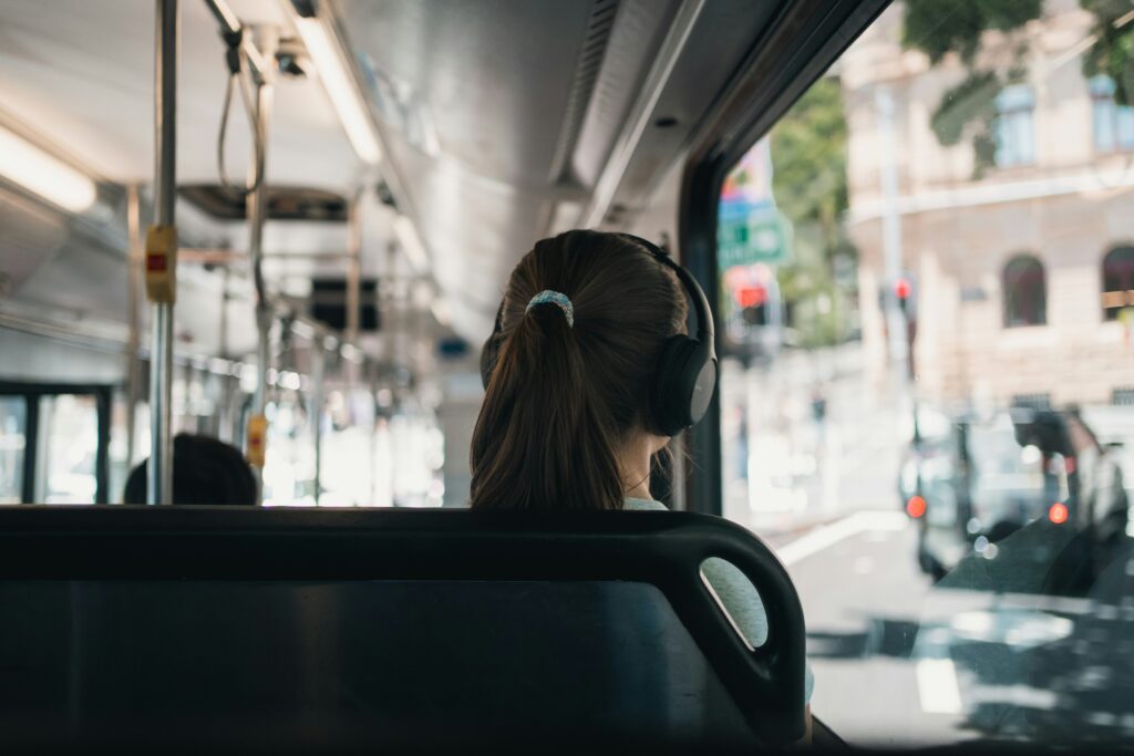 Dziewczyna w słuchawkach podróżująca autobusem.
