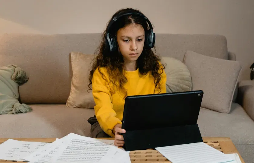 Um estudante usando fones de ouvido aprendendo onde o ReadSpeaker se encaixa no cenário da tecnologia assistiva para a educação.