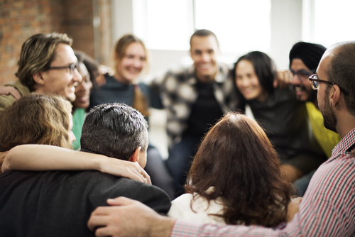 Happy multiethnic team, huddled together talking