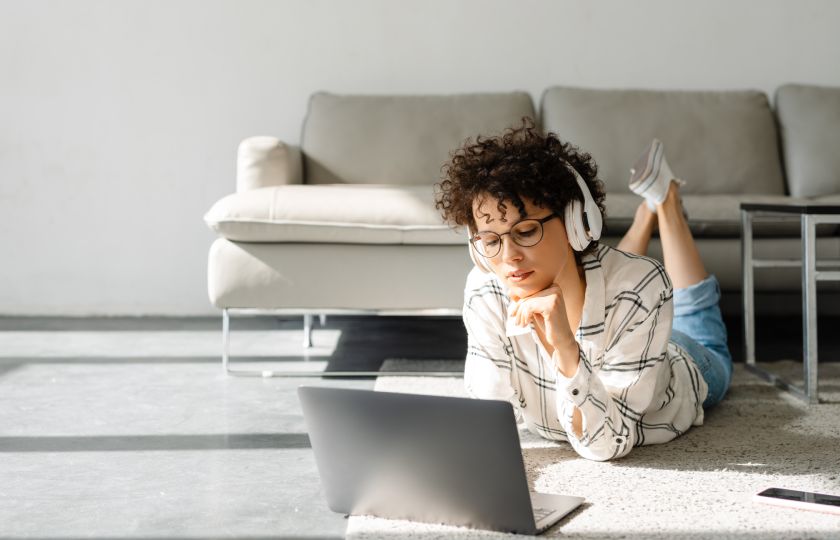 Étudiant portant un casque et écoutant un cours vocalisé sur son ordinateur portable.