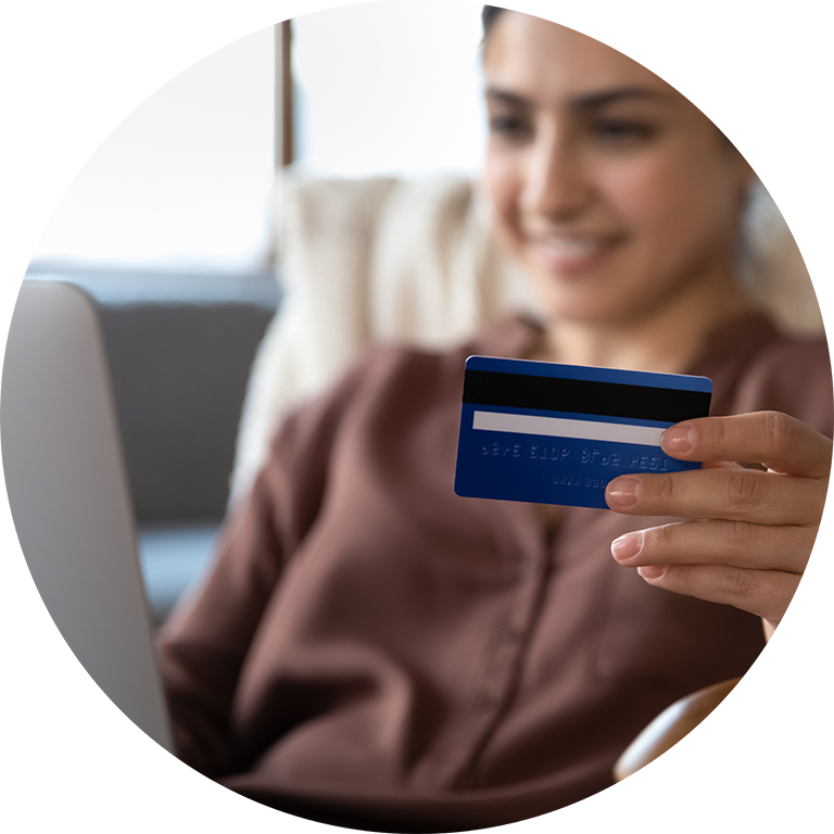 smiling woman talking to a voicebot holding credit card