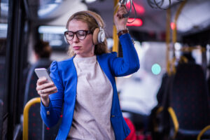 Geschäftsfrau hört Musik im öffentlichen Verkehr.