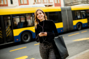 Jeune femme attendant un taxi ou un bus dans la rue d'une ville