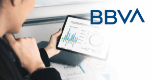 A person reviews financial charts on a tablet, with the BBVA logo displayed on the right side of the image.