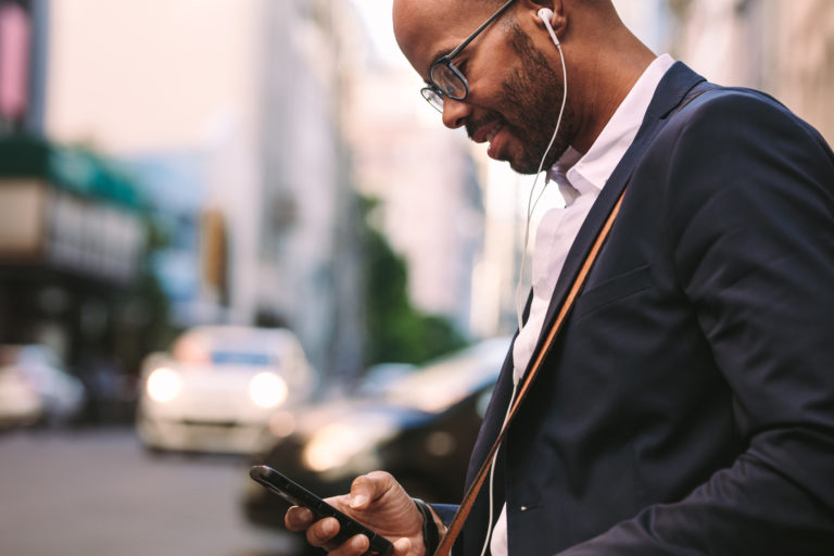 Businessman commuting with a smartphone and headphones.