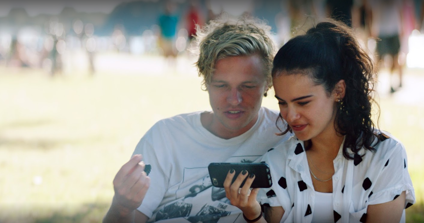 Jongen en meisje die samen naar een video kijken op een smartphone.